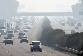 California freeway in smog and haze illustrating why smog checks are required